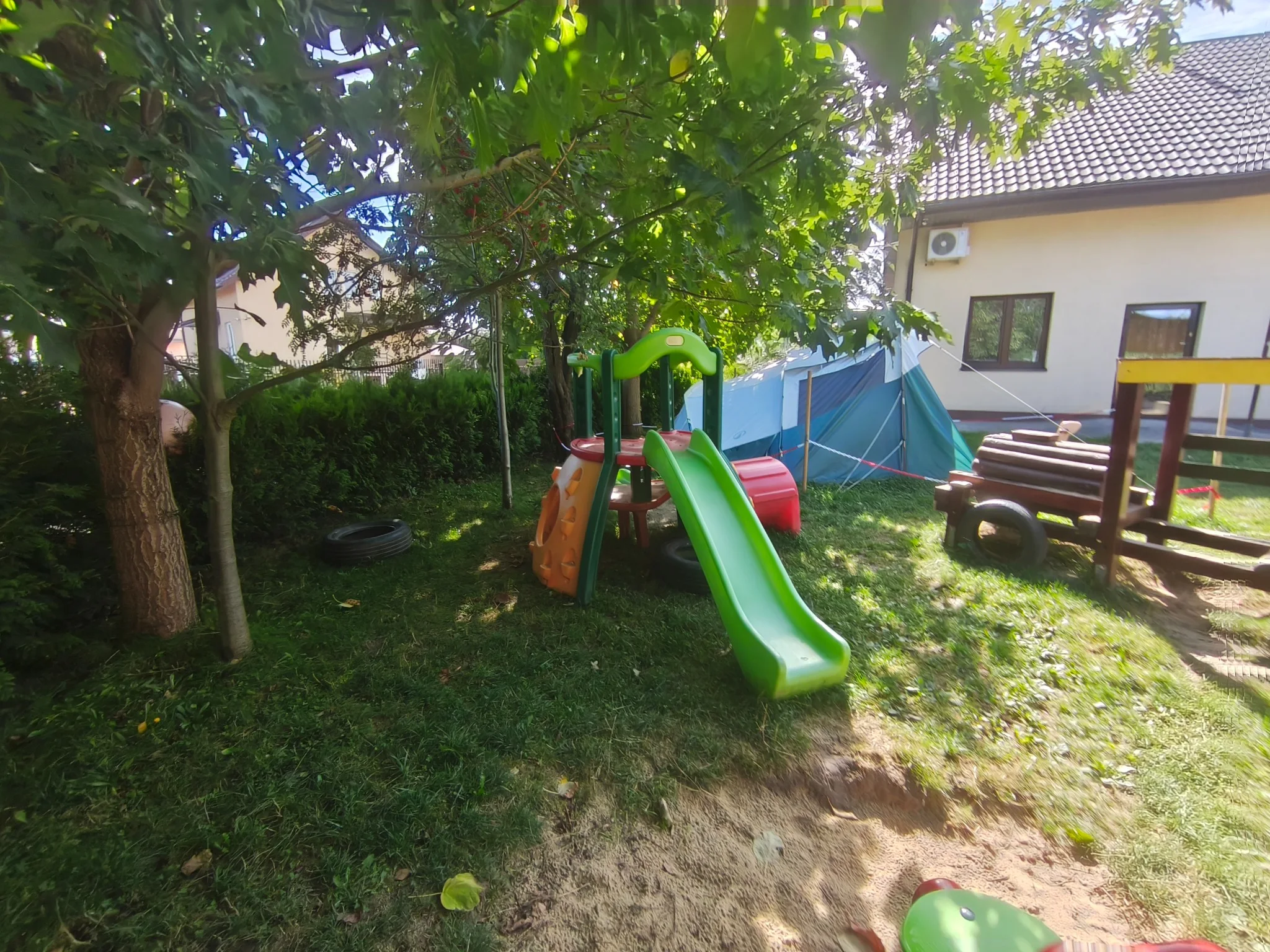 Zacieniona część ogrodu ze zjeżdżalnią